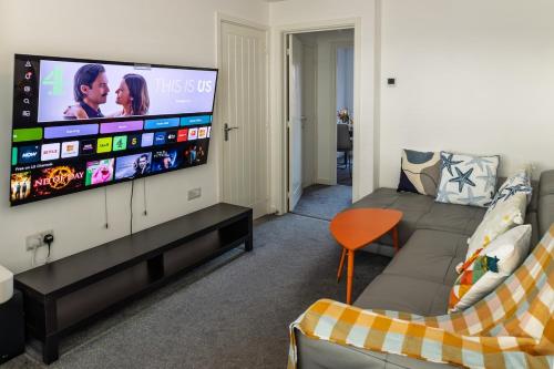 a living room with a couch and a flat screen tv at Affordable House By Amara Apartments Short Term Rental Agency Coventry in Longford