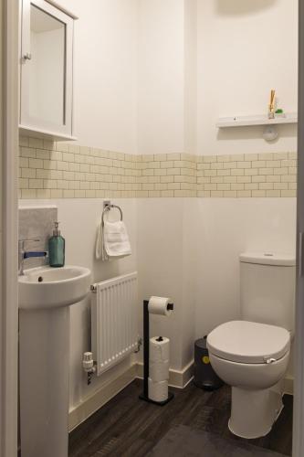 a white bathroom with a toilet and a sink at Affordable House By Amara Apartments Short Term Rental Agency Coventry in Longford
