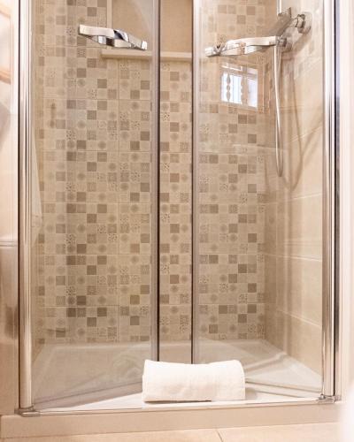 a shower with a glass door in a bathroom at La Stella Del Pupo TEODORA in Fasano