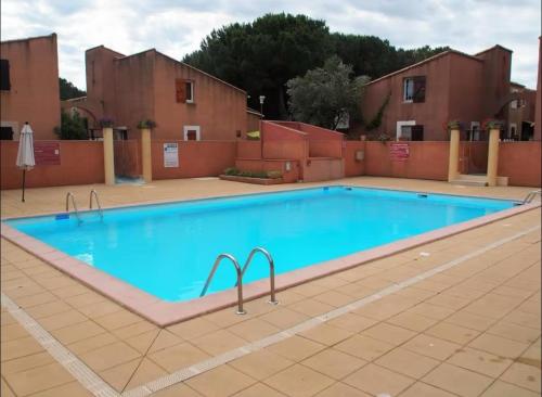 une grande piscine avec de l'eau bleue dans l'établissement Petite maison de vacances, au Cap d'Agde