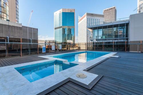 a swimming pool on top of a building with tall buildings at CLDN4- Studio in Central Sydney CBD with Pool in Sydney
