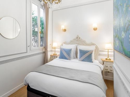 une chambre blanche avec un grand lit avec des oreillers bleus dans l'établissement Merveil - Luxury Suite - Louvre - Aboukir IV, à Paris