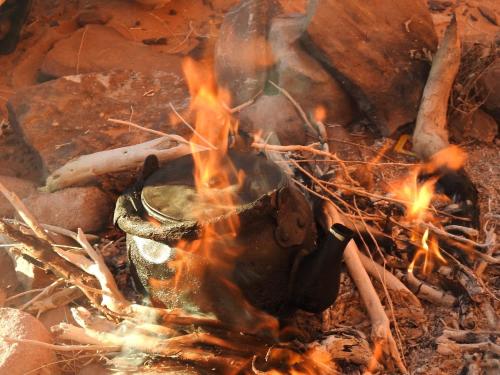 a camp fire with a pot on top of it at Wadi Rum Marina Camp in Wadi Rum