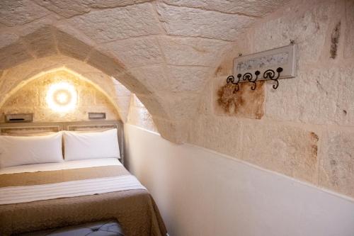 a bedroom with a bed in a stone wall at La Stella Del Pupo CATALDO in Fasano