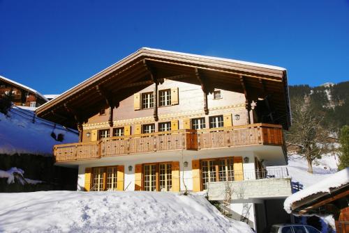 a large building with a balcony in the snow at Chalet Rivendell - GRIWA RENT AG in Grindelwald