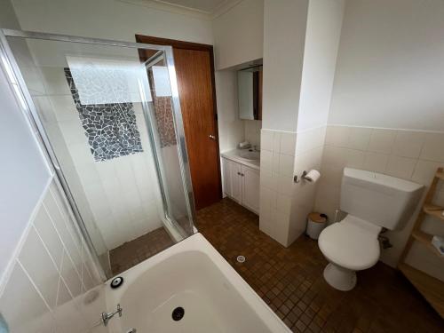 Un baño con bañera, inodoro y ducha. en Troobloo Townhouse in heart of Glenelg, en Glenelg