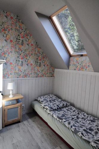 1 dormitorio en el ático con cama y ventana en Iskierkówka, en Brenna