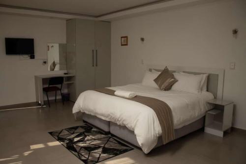 a bedroom with a large bed and a desk at Benmore Lodge in Ferrby