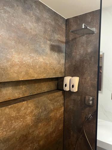 a bathroom with a shower with two speakers on the wall at Panelcz in Uherčice