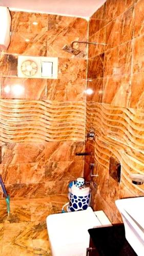 a bathroom with a toilet and a clock on the wall at Tourist Rest House , Guptkashi in Ukhimath