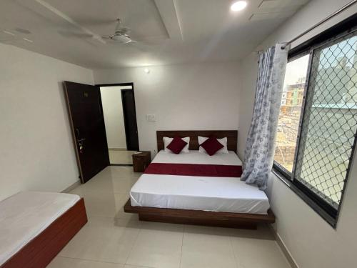 a bedroom with a bed and a window at Hotel Shree Radhe Laxmi in Khātu