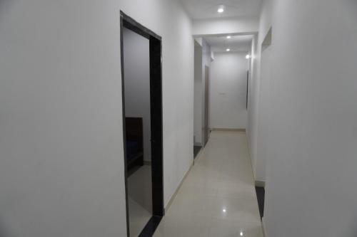 a hallway with white walls and a black door at Hotel Shree Radhe Laxmi in Khātu