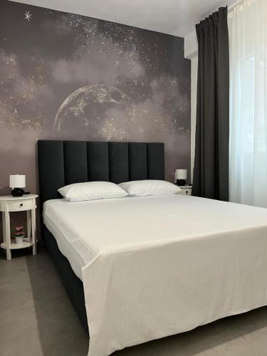 a bedroom with a large white bed with a black headboard at Blue Breeze Apart-Danai B in Ofrínion