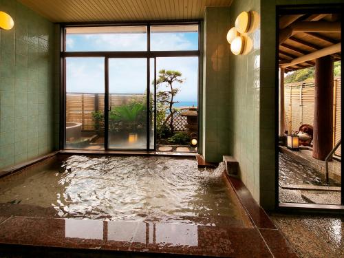 a pool of water in a room with a window at Yuhigauraonsen ShizukaHanaogi in Kyotango