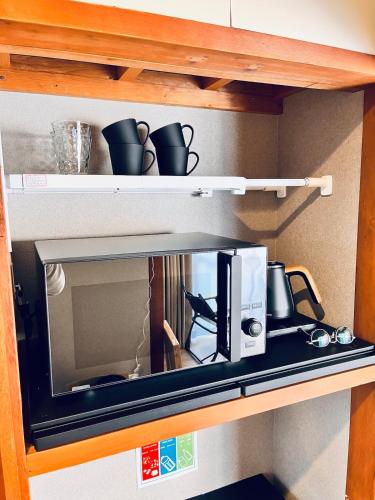 伊勢市にあるhotel 翡翠の棚の上に置かれた電子レンジ