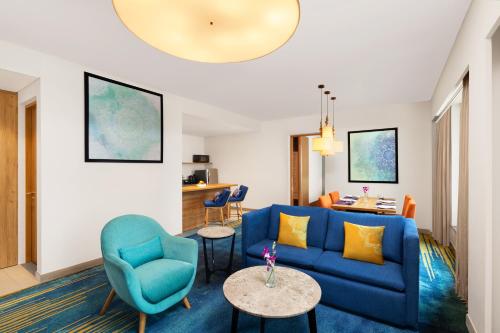 a living room with a blue couch and chairs at Grand Mercure Ahmedabad GIFT City - An Accor Hotels Brand in Gandhinagar