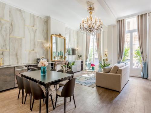 un grand salon avec une table et des chaises dans l'établissement Merveil - Luxury Suite - Louvre - Aboukir V, à Paris