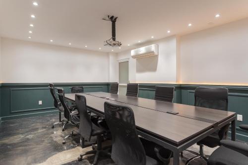 a conference room with a wooden table and chairs at Hangar Select Aeropuerto Guadalajara in Guadalajara
