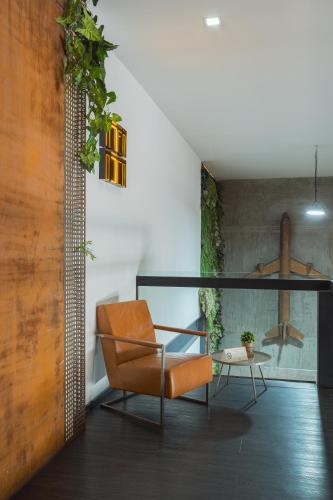 a living room with a chair and a table at Hangar Select Aeropuerto Guadalajara in Guadalajara