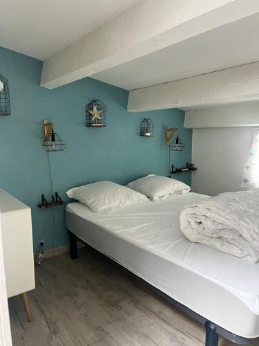 - un grand lit dans une chambre aux murs bleus dans l'établissement Petite maison de vacances, au Cap d'Agde
