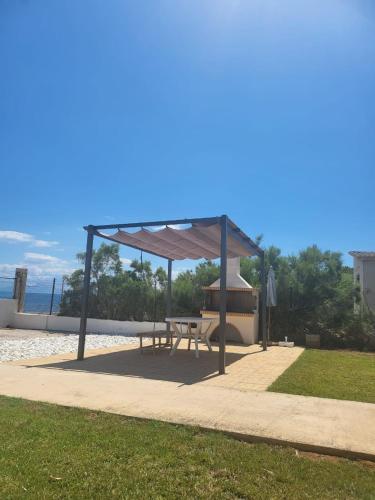 a picnic shelter with a picnic table on the beach at Beachfront Bliss Oasis in Melission