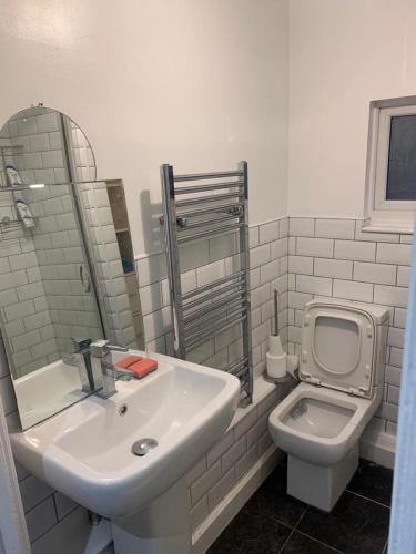a white bathroom with a sink and a toilet at The Ardens in Gillingham