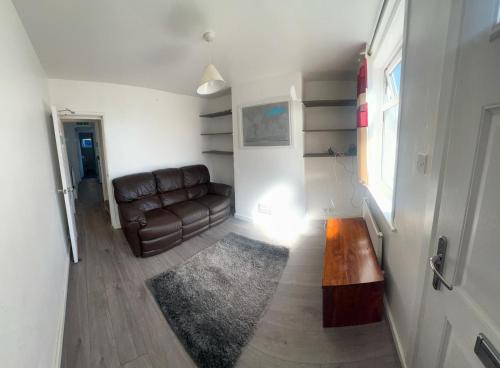 a living room with a leather couch and a rug at The Ardens in Gillingham