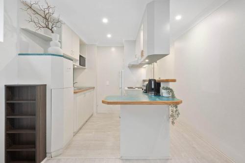 a kitchen with white walls and a blue counter top at Amazing Ocean View Studio at Bondi Beach in Sydney