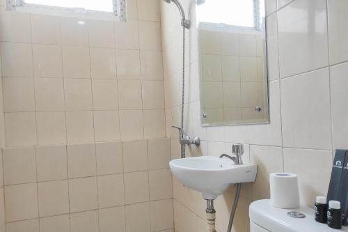 a bathroom with a sink and a mirror at Spacious 2BR at Vida View Makassar Apartment By Travelio in Pampang