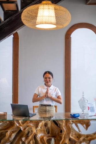 a woman standing in front of a table with a laptop at Micaela Bali Ubud Villas in Tegalalang