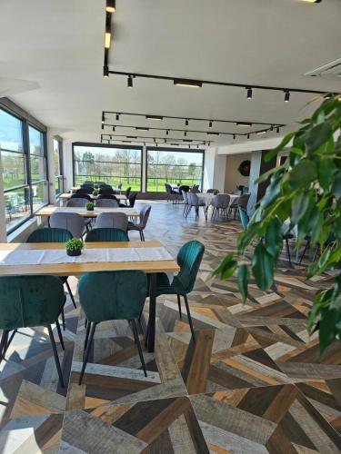 a large room with tables and chairs and windows at Danchev Hotel in Slivo Pole