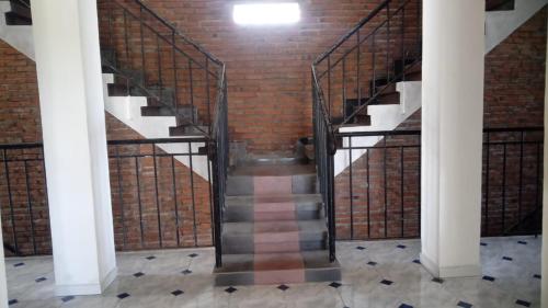 a staircase in an old brick building with metal railings at Hotel Arda Bali in Negara