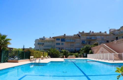 une grande piscine avec des bâtiments en arrière-plan dans l'établissement Apt sur 2 niveaux avec terrasse à Saint-Tropez, à Saint-Tropez