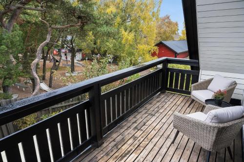 a balcony with two chairs and a view of trees at strand huset in Halmstad