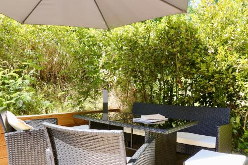 un patio avec une table, des chaises et un parasol dans l'établissement Apt sur 2 niveaux avec terrasse à Saint-Tropez, à Saint-Tropez