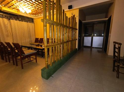 a dining room with chairs and a table and a fence at Rising Homestay in Guwahati