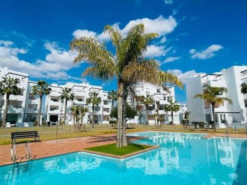 a palm tree sitting next to a swimming pool at La Casa de Pamael 2 bedroom apartment in Roldán