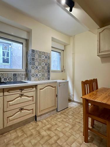 Il comprend une cuisine équipée d'un évier, d'un lave-vaisselle et d'une table. dans l'établissement Charmant Appartement - 2 chambres - Carcassonne Centre, à Carcassonne