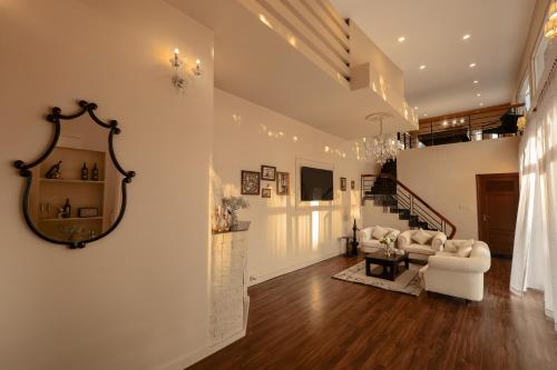a living room with white furniture and a mirror on the wall at De Lavie Villa DaLat in Khu Chi Lăng