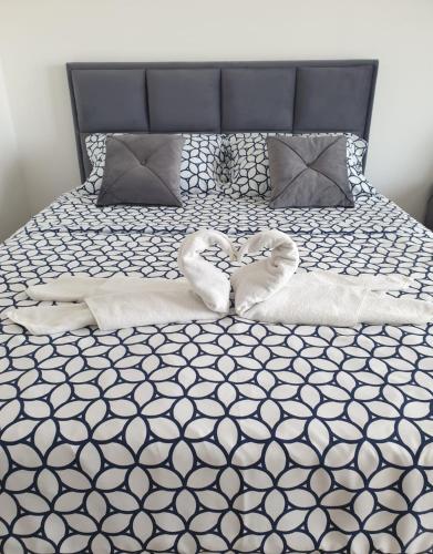 a bed with two towels in the shape of hearts at Delta Lux Apartman in Niš