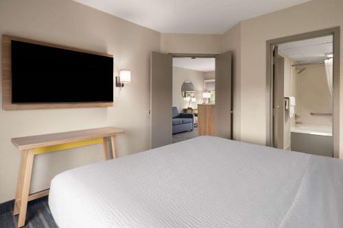 a hotel room with a bed and a flat screen tv at Days Inn by Wyndham Weldon Roanoke Rapids in Weldon