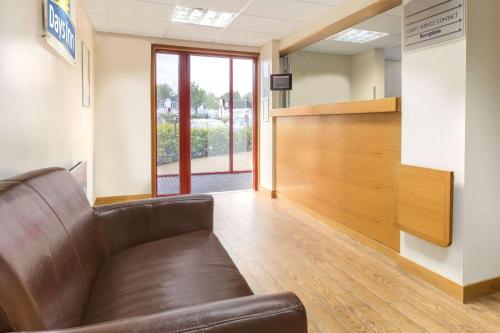 a leather couch in a waiting room with a wooden partition at Days Inn Magor in Magor