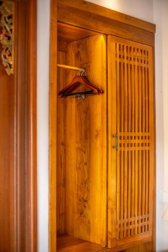 a wooden cabinet with a door in a room at Micaela Bali Ubud Villas in Tegalalang