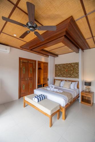 a bedroom with a bed and a ceiling fan at Micaela Bali Ubud Villas in Tegalalang