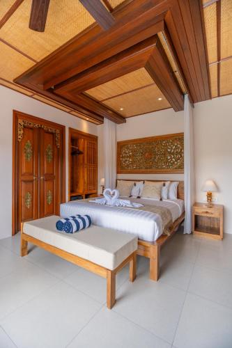 a bedroom with two beds and a wooden ceiling at Micaela Bali Ubud Villas in Tegalalang