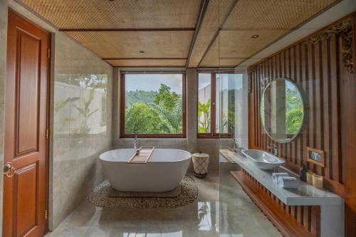 a bathroom with a large tub and two sinks at Micaela Bali Ubud Villas in Tegalalang