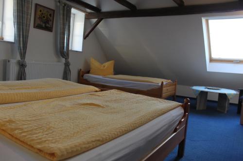 a bedroom with two beds and a window at Kutschergasthof Am Sonnenstein in Sonnenstein