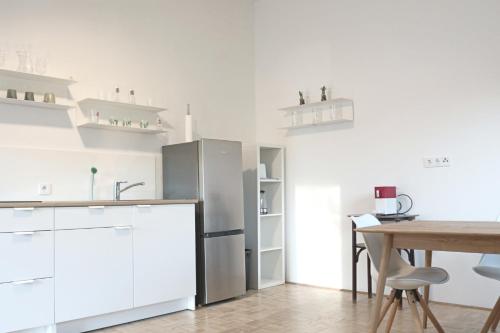 デーブリアッハにあるTop Five See & Bergblick - Haus Seepromenadeのキッチン(ステンレス製の冷蔵庫、テーブル付)