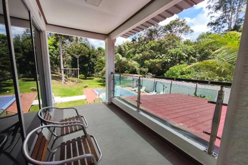 a porch with two chairs and a view of a pool at AlSafina Forest Stay in Kemaman