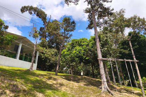 a fence in front of a house with trees at AlSafina Forest Stay in Kemaman